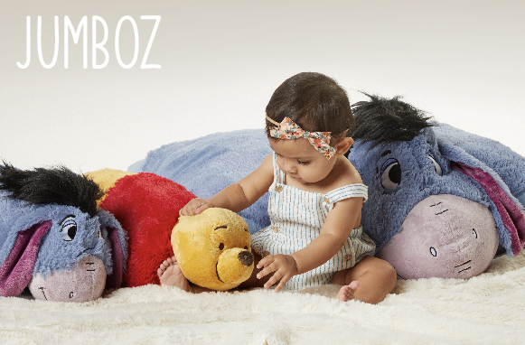 Click here to shop Jumbo Pillow Pets, showing a baby sitting next to Disneys Jumbo Eeyore Pillow Pet, Disneys Winnie the Pooh Pillow Pet, and Disneys Eeyore Pillow Pet.