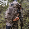 Hunter wearing the Team Elk Pack in rugged terrain, showcasing its ergonomic design and load-bearing capabilities.
