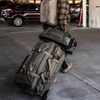 Atlas Duffel rolling through an urban environment with extended handle and hard-shell bottom visible.Hard-shell bottom of the Atlas Duffel with integrated wheels, shown at an angle to highlight structure.