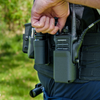 Close-up of a hand adjusting volume of a Motorola radio from the Zero9 case worn on a duty belt outdoors