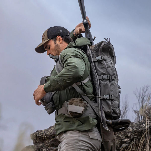 Hunter carrying the scabbard on a pack, highlighting low-profile design for mobility.