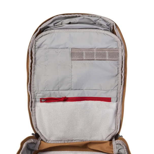Vertx Siege 15L Sling Pack VTX5306 coyote brown front panel interior open showing gray-lined organization panel with Velcro patch field and red zipper pull on zip pocket