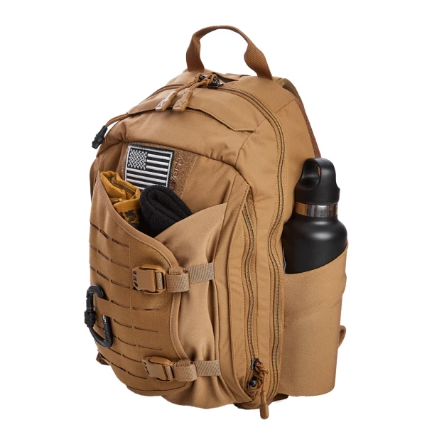 Vertx Siege 15L Sling Pack VTX5306 coyote brown three-quarter front lifestyle view showing American flag patch on Velcro panel, water bottle in stretchable side pocket, and expandable front pocket loaded with gear