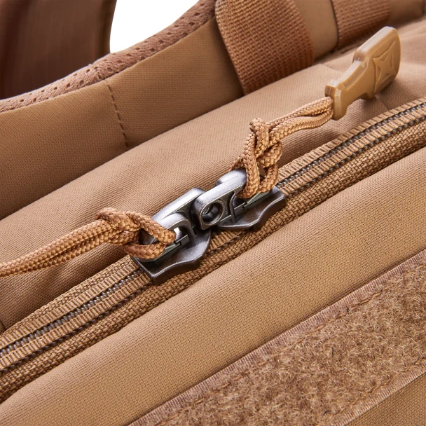Vertx Siege 15L Sling Pack VTX5306 coyote brown close-up of dual zipper pulls on main compartment showing cord pull detail and MOLLE webbing along zipper edge