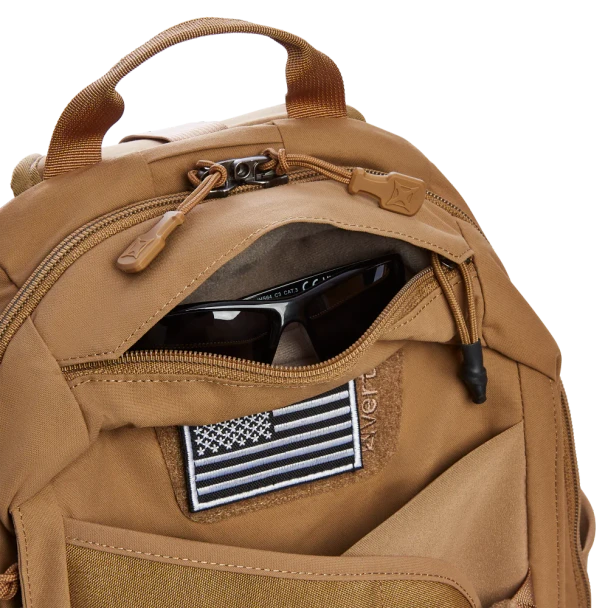 Vertx Siege 15L Sling Pack VTX5306 coyote brown top pocket open showing sunglasses stored inside with American flag patch on front Velcro panel below