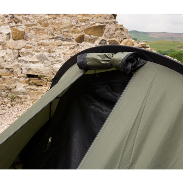 Snugpak Scorpion 2 IX olive close-up of door opening showing rolled mosquito net bundled at top of pole arch above the opening with dark mesh inner tent and zipper pull visible below
