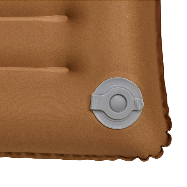 Snugpak Basecamp Air Pillow coyote tan close-up of gray twist-lock inflation and deflation valve showing circular disc housing and center push button detail on stretch fabric surface
