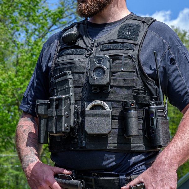 Officer wearing a plate carrier with the Zero9 OC spray case mounted on the front, outdoors