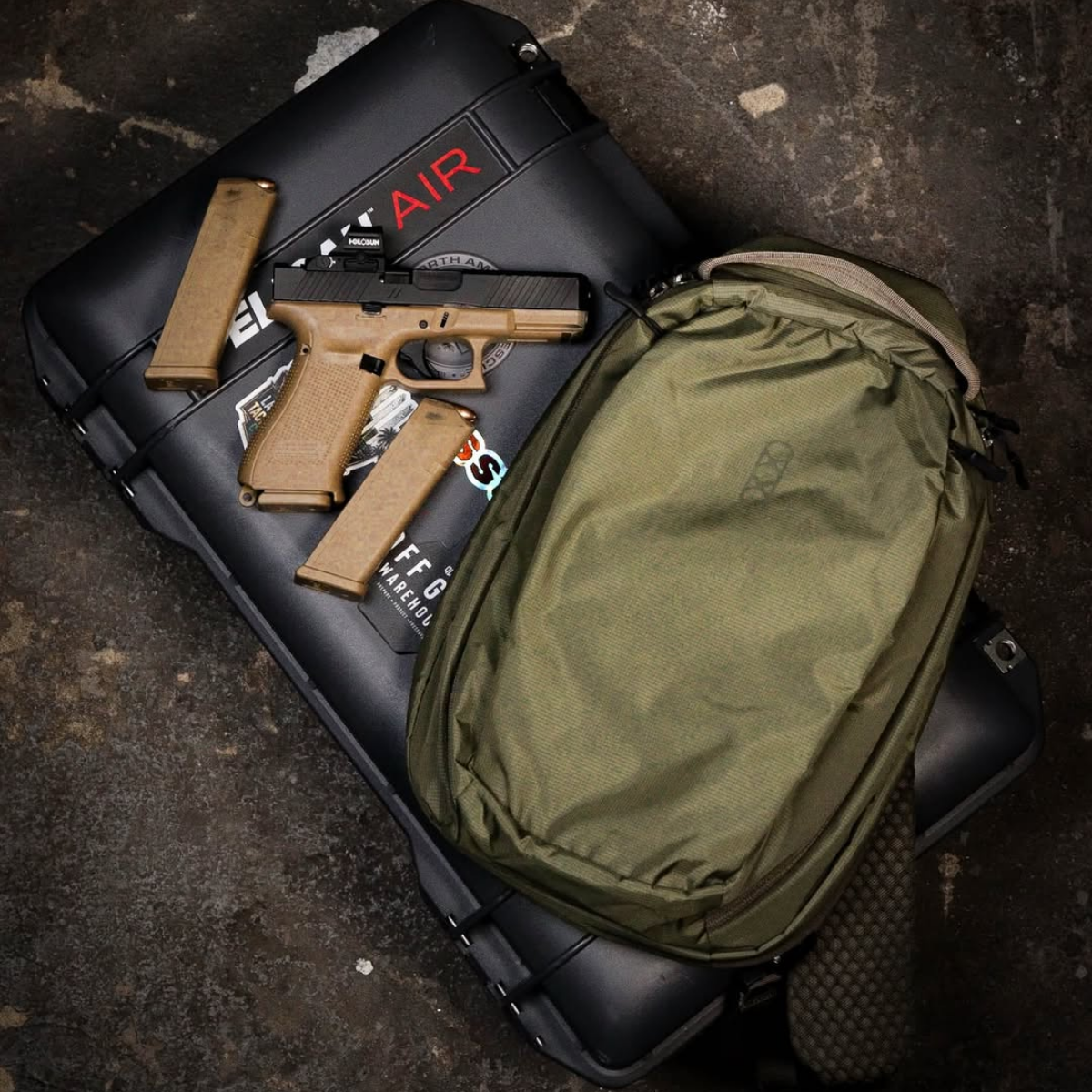 Pistol, mags, and pack staged on a Pelican case