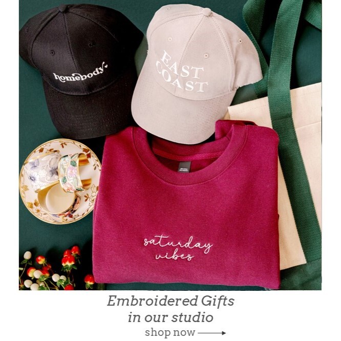 Personalized embroidered sweatshirt, hats, bracelets and bag. Shown on green background with holly.