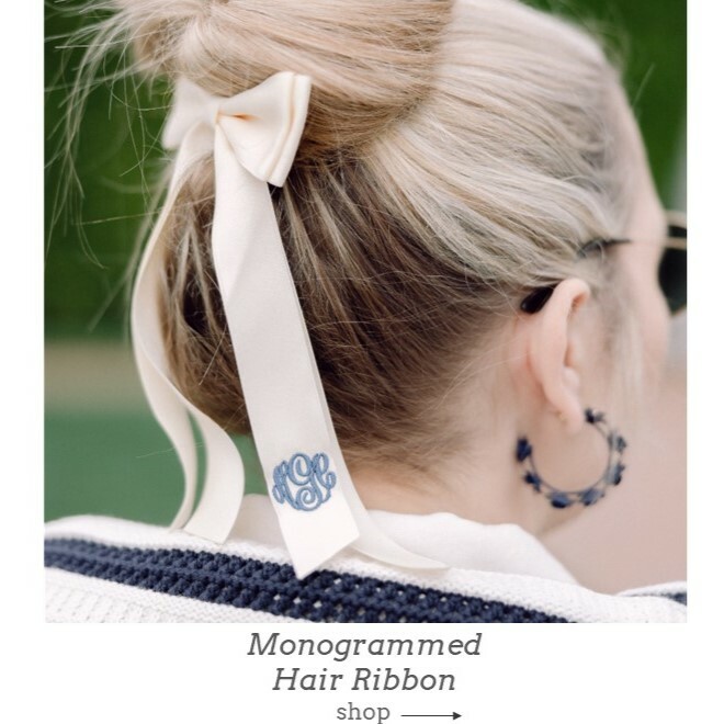 Monogrammed hair ribbon in cream with navy embroidery thread shown on woman.