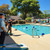 Guests playing cornhole by the pool with custom-designed boards. Ideal for backyard gatherings, beach weddings, and outdoor celebrations.