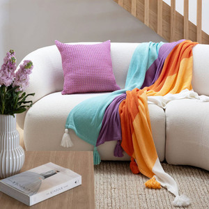 Azalea cotton throw bold and bright draped over white couch Azalea cotton throw bold and bright draped over white couch