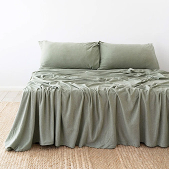 Sage Green Bambury BedT Organica sheets styled on a made bed, highlighting the smooth knitted finish and breathable drape