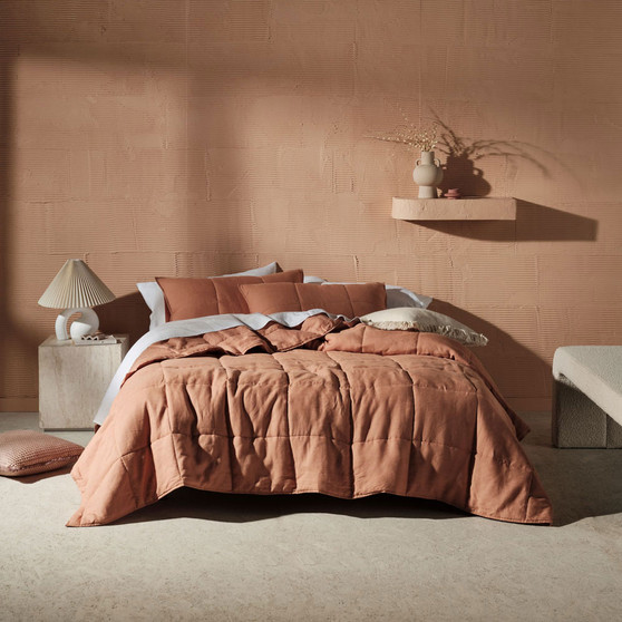 Linen House Nimes clay coverlet styled on a bed, showcasing its vintage linen drape and generous queen–king fit