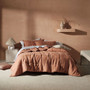 Linen House Nimes clay coverlet styled on a bed, showcasing its vintage linen drape and generous queen–king fit