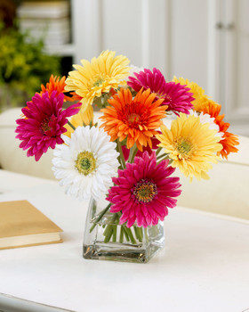 Colorful lifelike silk gerbera daisy centerpiece set in crystal clear acrylic water in glass vase
