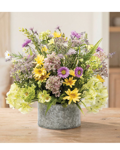 Daisies, lavender, and lilacs faux flower centerpiece arranged in a 7.5 inch galvanized metal bowl, featuring a free-spirited wildflower design with lifelike summer meadow blooms, 17 inches high by 19 inches wide