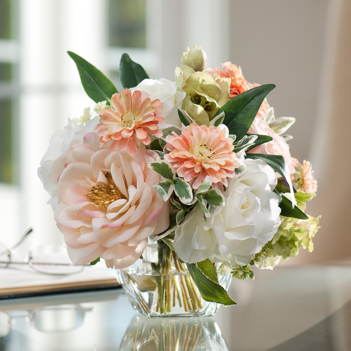 Peaches and cream silk flower arrangement in glass vase