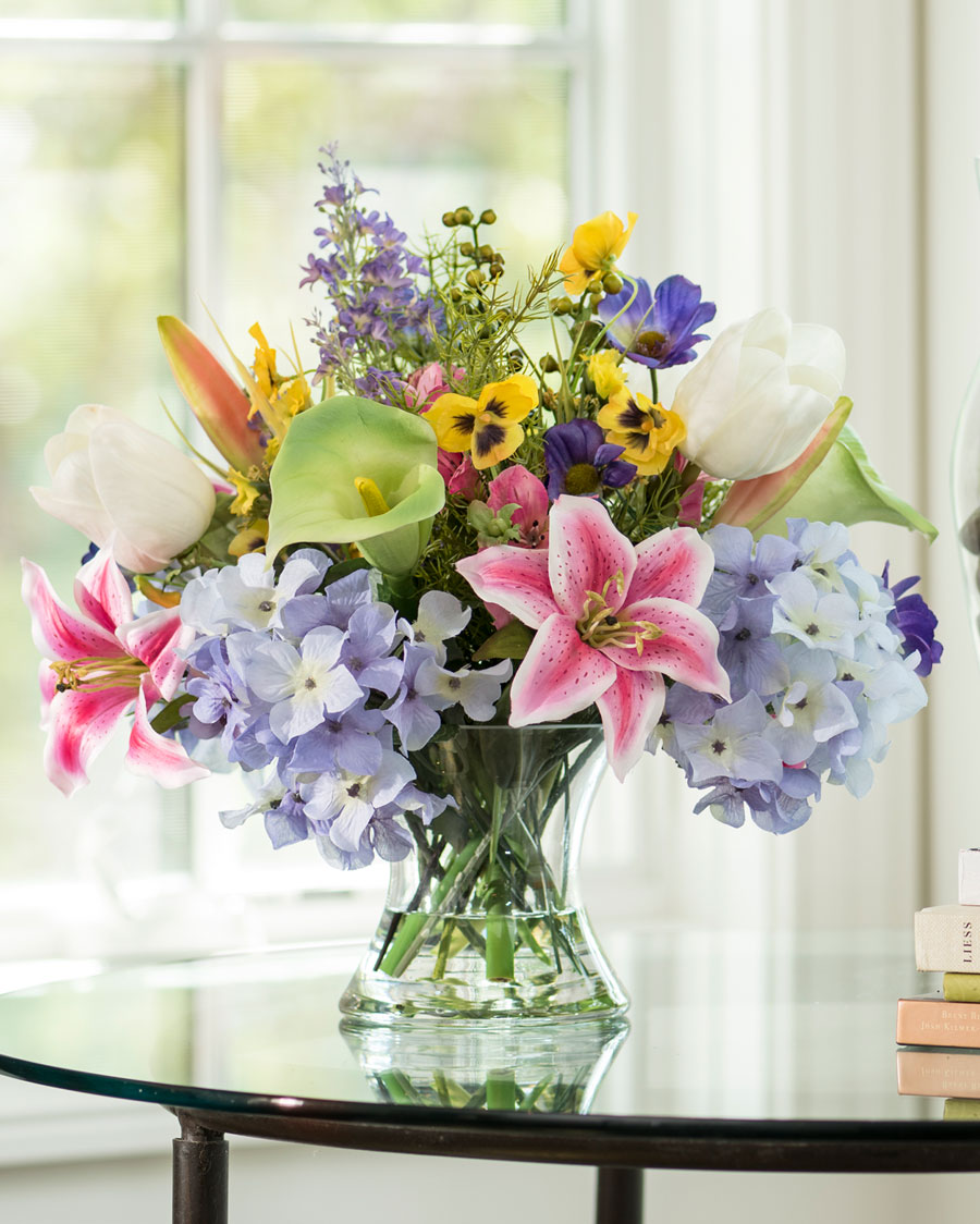 Hanging greenery, calla lilies, and roses were used to create this