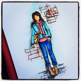 Mixed-media card with a stylish stamped girl in a scarf, teal jacket and jeans on a grid-print background.