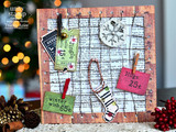 Vintage Christmas ticket tags — 'winter wish,' 'Jingle bells,' 'Hugs' — pinned to a wood board with a knit stocking.