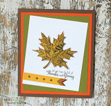 Golden patterned maple leaf on a white panel matted in olive and orange with 'Let our lives be full of Thanks and Giving.'