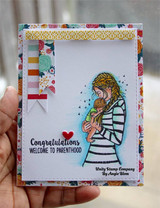 The mother in a striped top holding her baby on a floral card, captioned "Congratulations, welcome to parenthood."