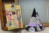 A tag and two paper party hats styled together, the tag stamped with the girl and 'may your birthday be filled with JOY ......and wine'.