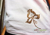 Pink T-shirt hem stamped with the tulip in metallic bronze and dotted with clear rhinestones, showing the set used on fabric.