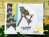 Card with the flower-basket bicycle colored in red and yellow inside a white circle, layered over black 'love' print paper and stamped 'I'D GO ANYWHERE WITH you.'