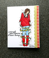 White card with Nora colored in a red sweater, blue jeans and red boots tangled in a green garland, with a red striped border and the sentiment.