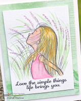 Soft green watercolour card, the girl coloured with pale blonde hair and a pink top among wispy lavender grasses, with "Love the simple things life brings you" lettered below.