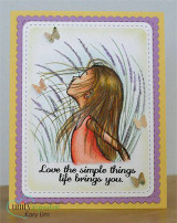 Card with a scalloped purple and gold frame, the girl coloured with auburn hair and a coral top among soft lavender grasses, tiny butterflies and the sentiment "Love the simple things life brings you".