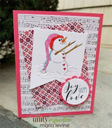 Card with a snowman in a pink hat holding a star on music-sheet paper and 'Joy Happy Love.'