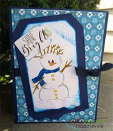 Card with a blue-scarf snowman on a navy snowflake panel and 'Shine Bright.'