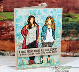 Card with the two friends colored in layered outfits over patterned paper and the 'good friend' sentiment.
