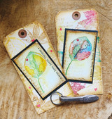 Two tags with leaves stamped in rainbow watercolor