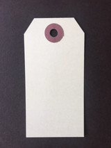A second view of the 1-7/8 by 3-3/4 inch manila craft tag from Unity Stamp Co, blank and ready for stamping, on a dark background.