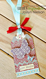 Gift tag with a red zigzag band, a purple numbered butterfly, a small blue butterfly, a 'HAPPY BIRTHDAY' strip, and aqua and red ribbons.