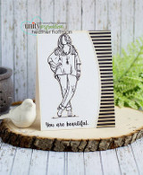Card with a stamped girl in jeans and a sweater, hands in pockets, 'let the beauty of who you are be the director of your dreams,' on white with a striped panel.