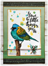 Green card with the bird in teal and gold on a splattered white panel over script-printed paper, with the I love the little things you do sentiment.