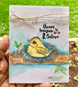 Sample card with a yellow bird in its nest on a watercolor branch and 'Dream Imagine & Believe'.