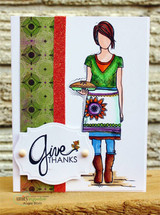 White card with a green patterned strip and the girl in a green top and teal apron holding a pie beside a 'Give THANKS' label.