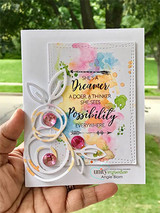 Card with the 'She's a dreamer' text over a soft watercolor background with a leafy die-cut.