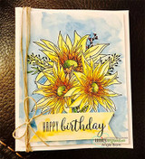 Watercolored card with bright yellow sunflowers layered on a book page, stamped 'Happy birthday.'