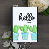 Clean white card with three cactuses in blue chevron pots in a row beneath a large black hello script and the word PRICK.