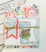 Card with the floral coffee mug colored in soft pinks and greens over patterned paper with a heart and twine bow.