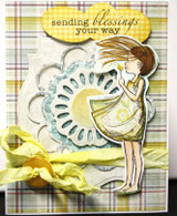 The dandelion girl in a yellow dress on a plaid card with 'sending blessings your way.'