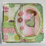 The dandelion girl in a green dress on a soft pink oval with buttons and lace.